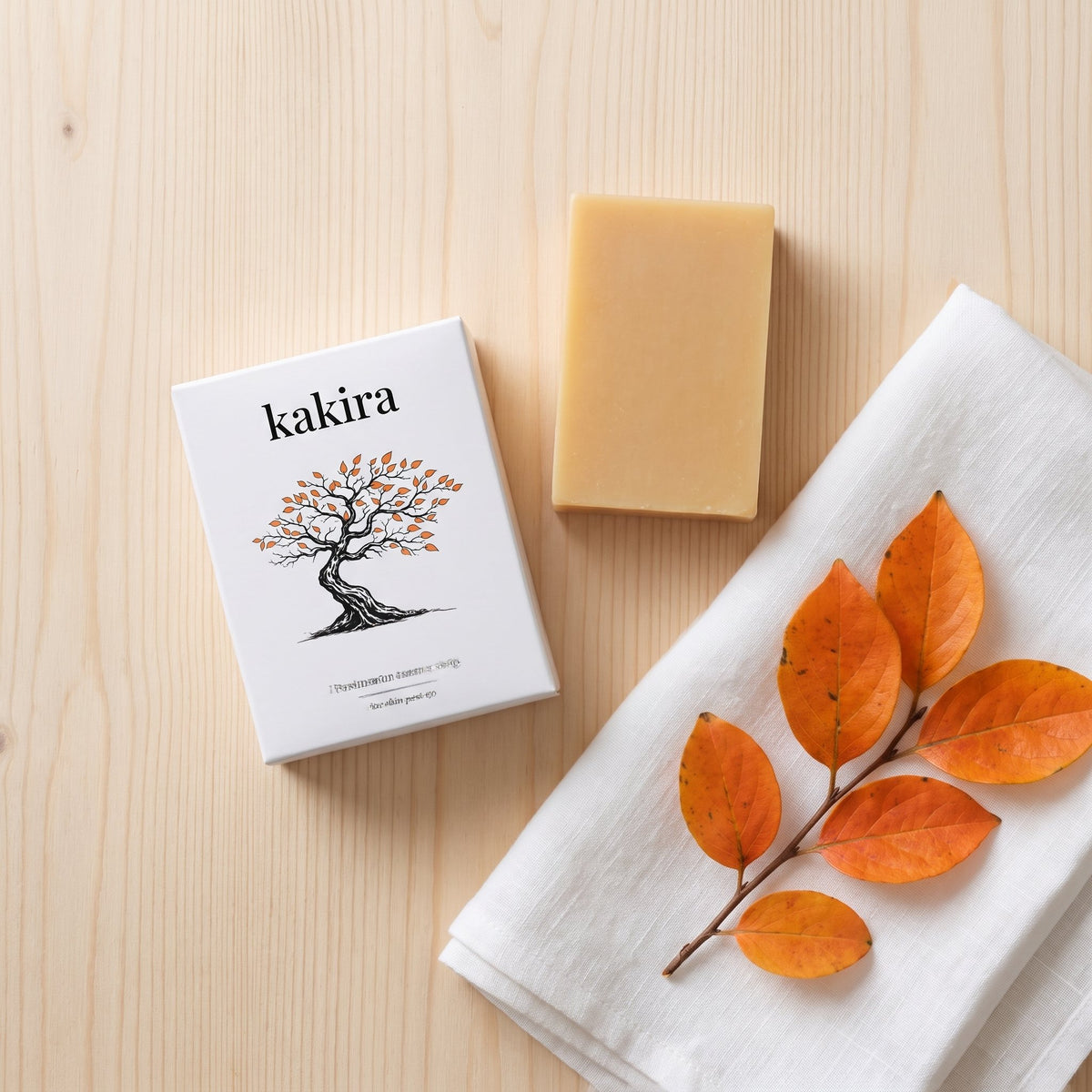 kakira box, bar, linen and persimmon leaves on pale wood