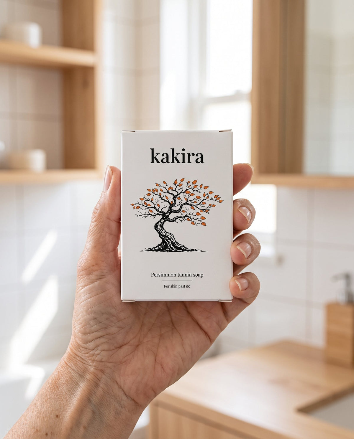 A hand holding the kakira box in a bright bathroom
